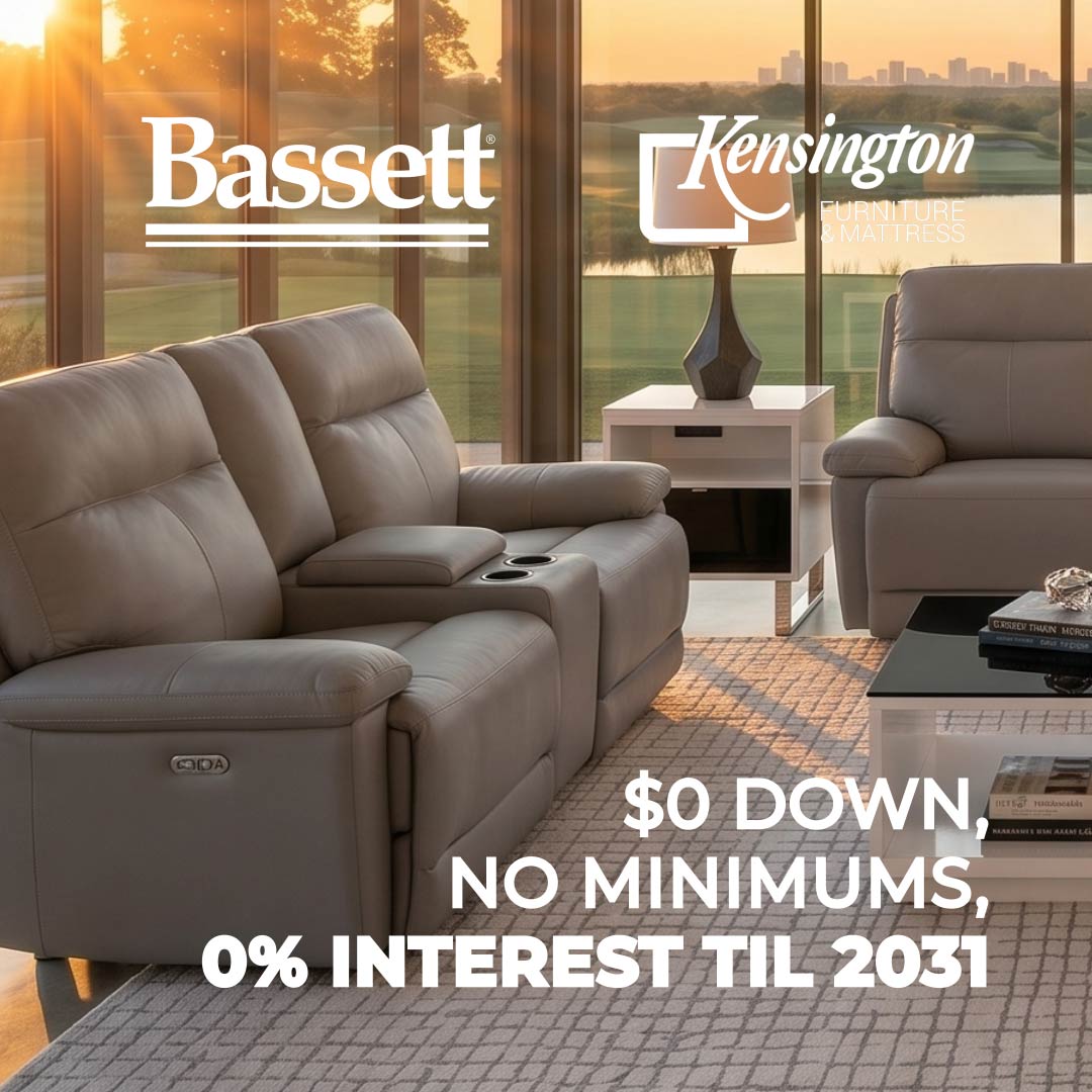 A large gray leather reclining loveseat sofa shown in a modern living room setting with a matching armchair, glass windows, and a sunset view outside. Prominent text overlays include the Bassett and Kensington brand names, along with promotional financing text.